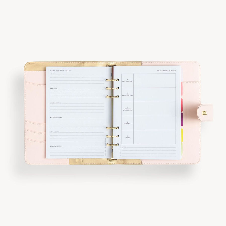 Open blush A5 vegan leather planner with, gold lining and goal pages, and a gold clasp on the front cover.