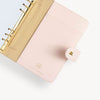 Open blush A5 vegan leather planner with a gold clasp on the front cover.